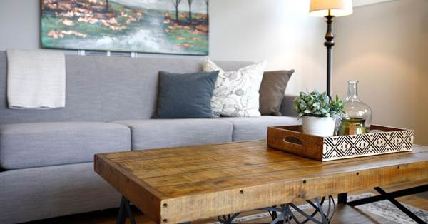 A wooden coffee table in front of a gray sofa