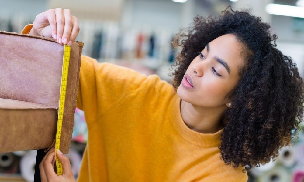 A lady is measuring the chair with a ruler